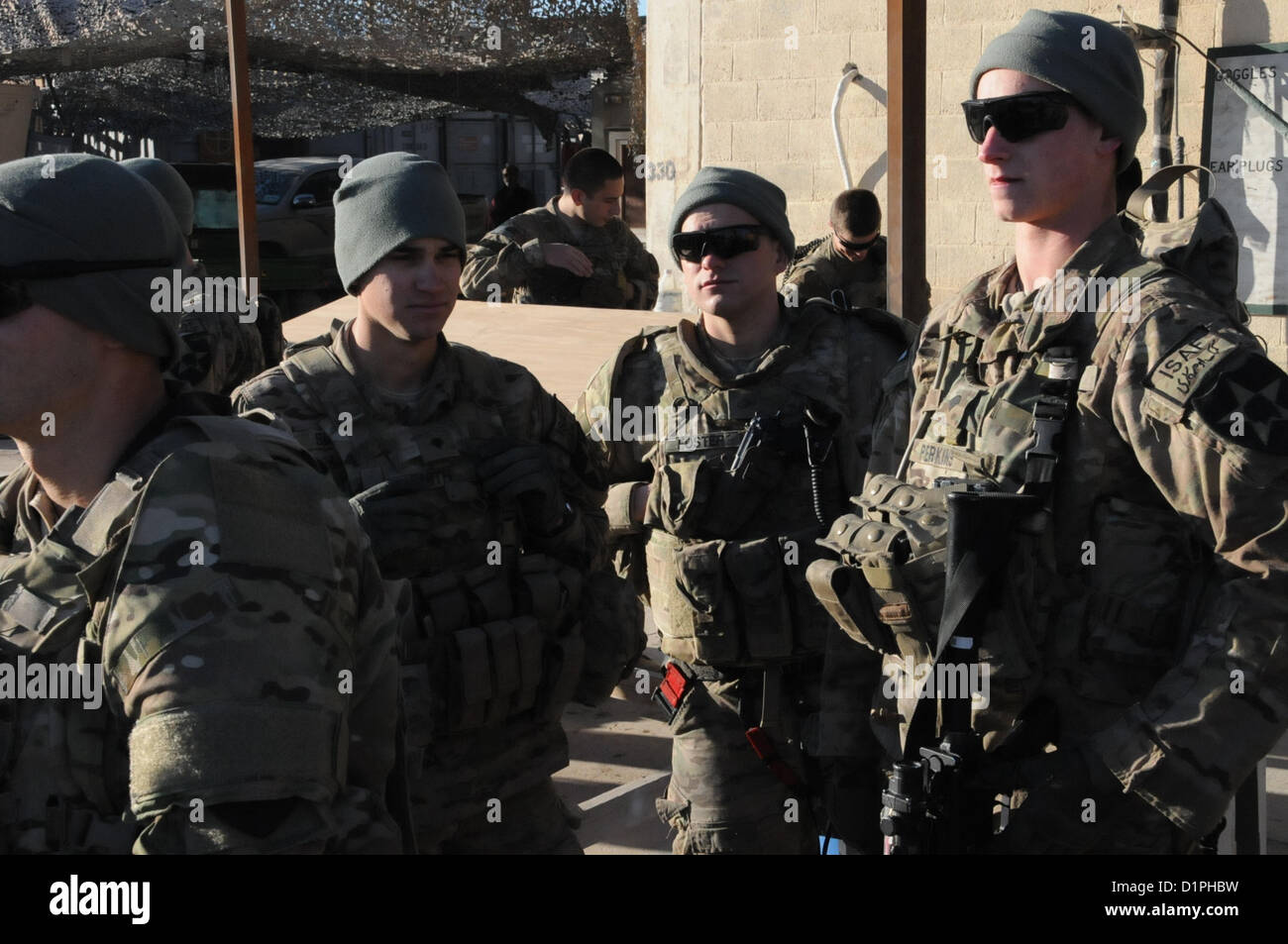 U.S. Army Spc. Dalton Smith, Pfc. Ian Foster and Spc. Devon Perkins, left to right, security force soldiers for Provincial Reconstruction Team (PRT) Farah, await a pre-mission briefing on FOB Farah, Jan. 2.  PRT Farah's mission is to train, advise, and assist Afghan government leaders at the municipal, district, and provincial levels in Farah province Afghanistan.  Their civil military team is comprised of members of the U.S. Navy, U.S. Army, the U.S. Department of State and the U.S. Agency for International Development (USAID).  (U.S. Navy photo by Lt. j.g. Matthew Stroup/released) Stock Photo