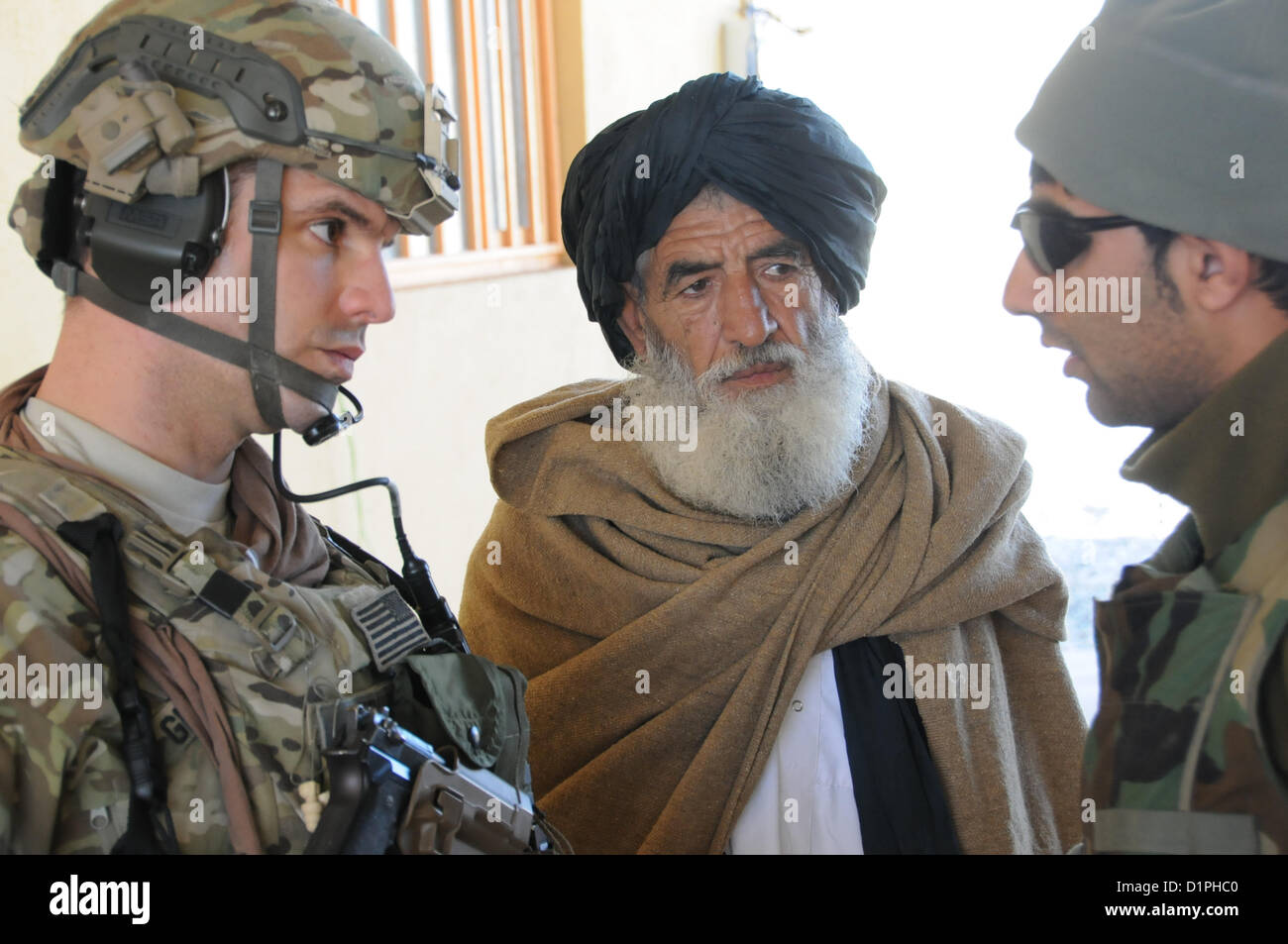 U.S. Army Capt. Jeremiah Gebhart, a civil affairs officer for Provincial Reconstruction Team (PRT) Farah, left, talks with a local Afghan elder through an interpreter at the Bala Boluk district center, Jan. 2.  PRT Farah's mission is to train, advise, and assist Afghan government leaders at the municipal, district, and provincial levels in Farah province Afghanistan.  Their civil military team is comprised of members of the U.S. Navy, U.S. Army, the U.S. Department of State and the U.S. Agency for International Development (USAID).  (U.S. Navy photo by Lt. j.g. Matthew Stroup/released) Stock Photo