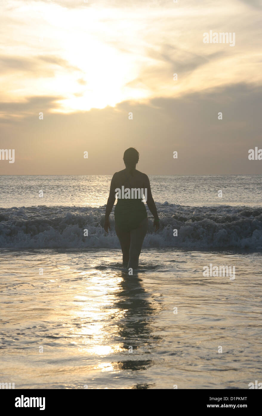 Woman stands in the surf at a beach in Costa Rica. Stock Photo