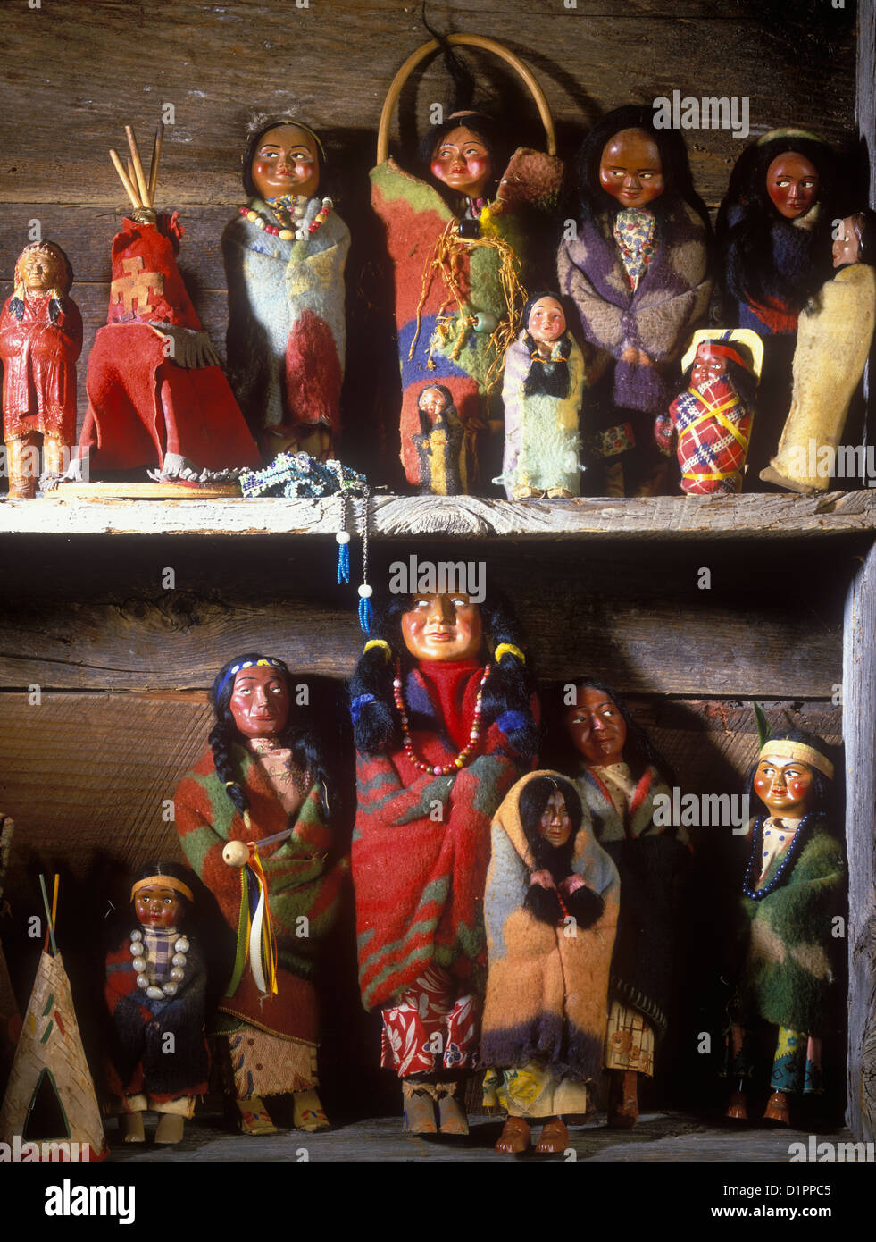 COLLECTION DISPLAYS - Vintage Native American dolls on display on shelves in rustic log home. Very colorful. Stock Photo