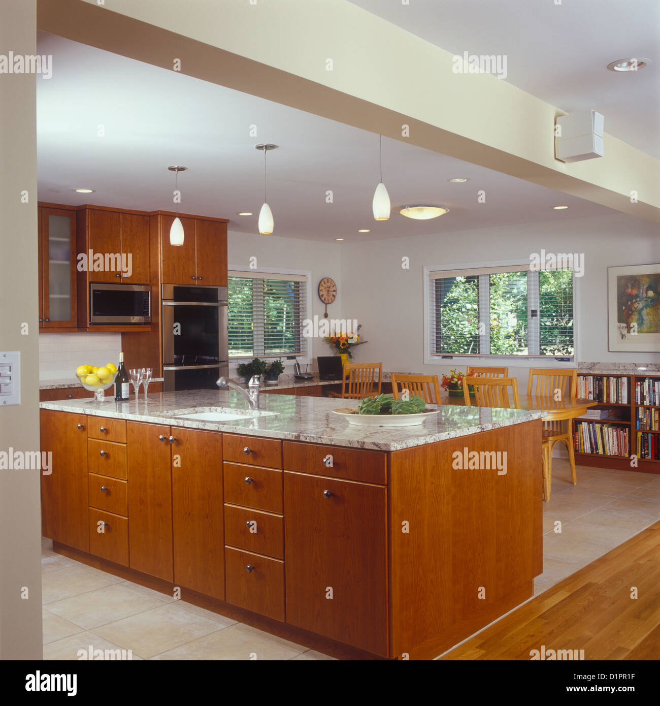 KITCHENS View towards island counter and family eating area rich cherry stained wood cabinets granite counters kitchen desk Stock Photo