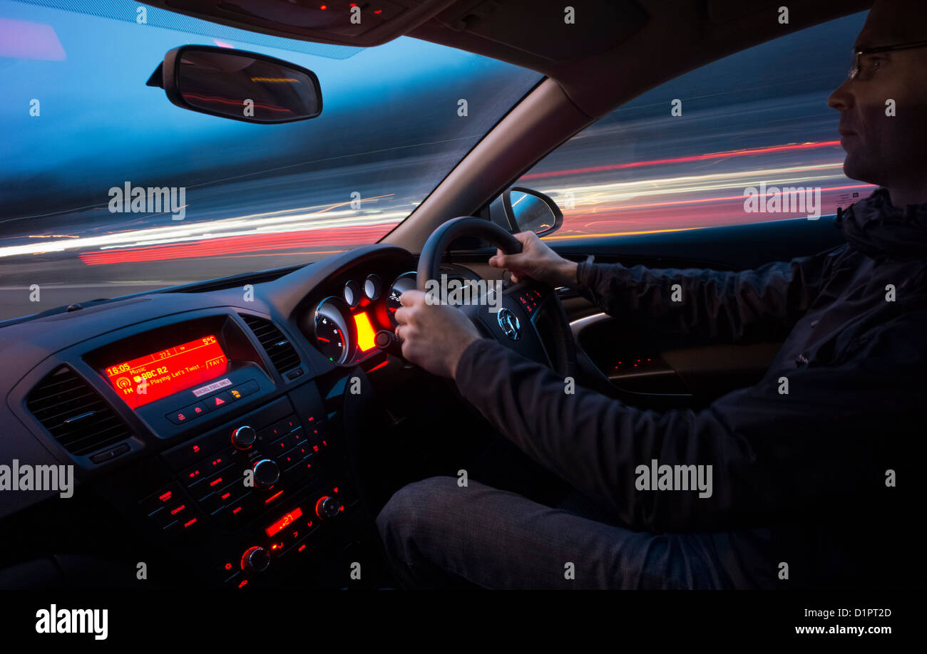 Driving fast down a motorway at night from inside the car. Stock Photo