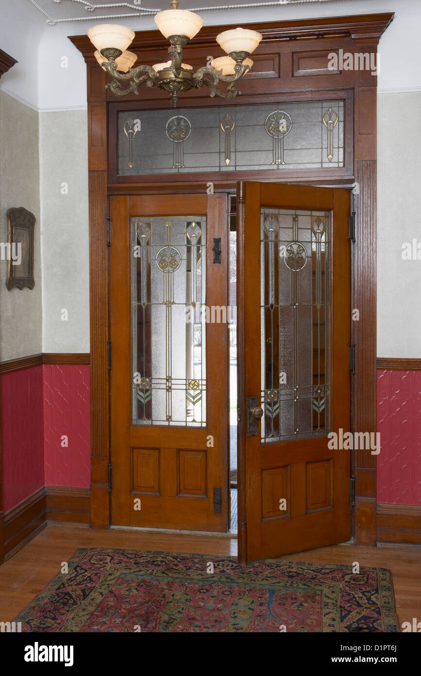 ENTRY HALL Arts and Crafts  front entry French doors with leaded and stained glass transom detailed architectural trim dado Stock Photo