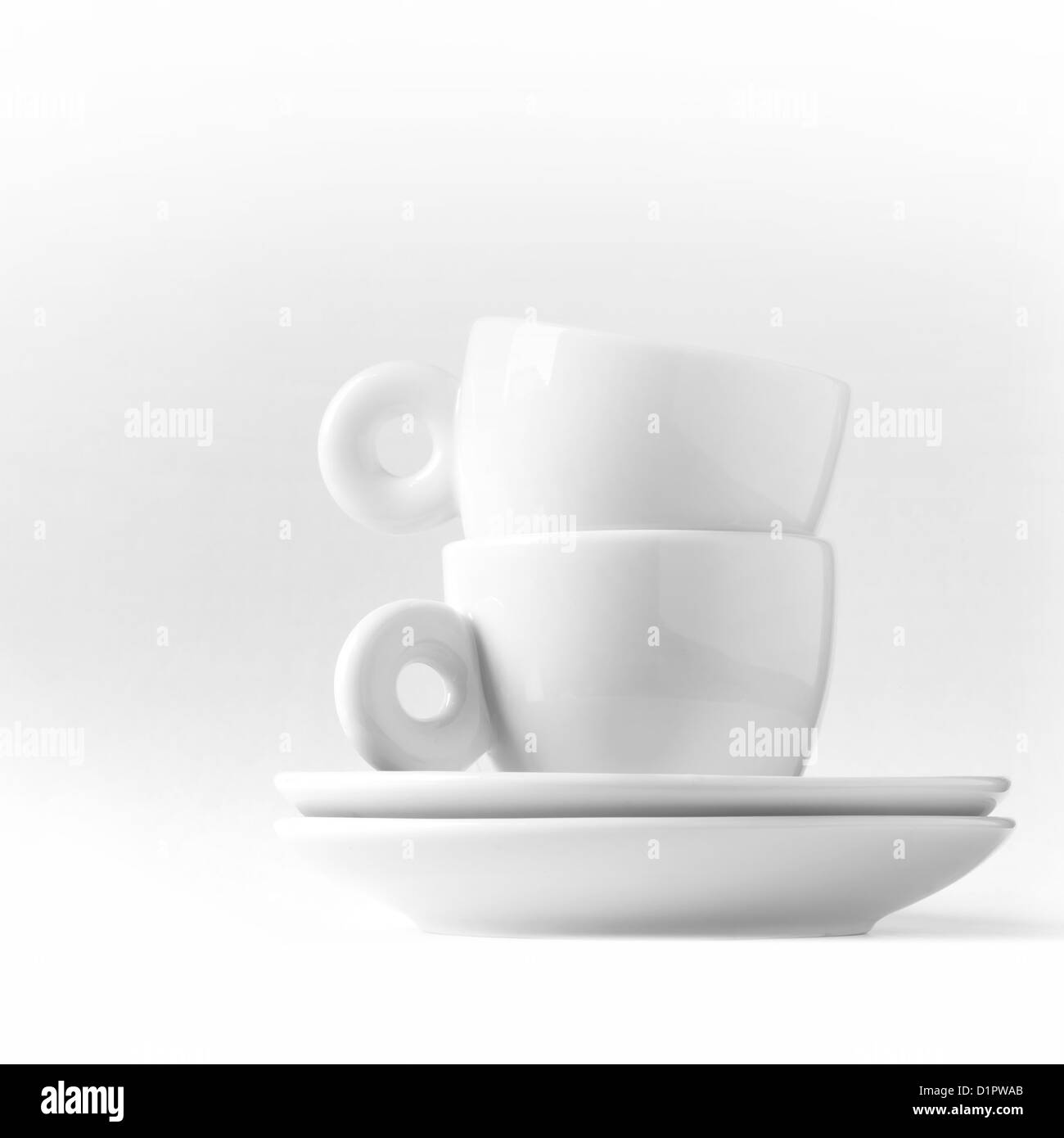 Double espresso metaphor with two small white cups Stock Photo