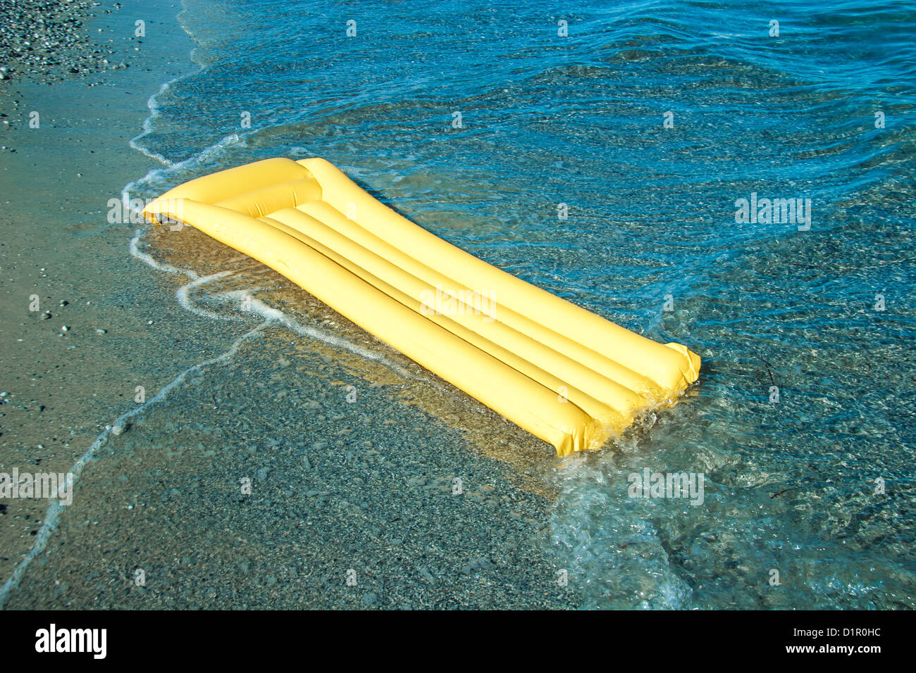 Yellow Floating air mattress on the beach Stock Photo - Alamy