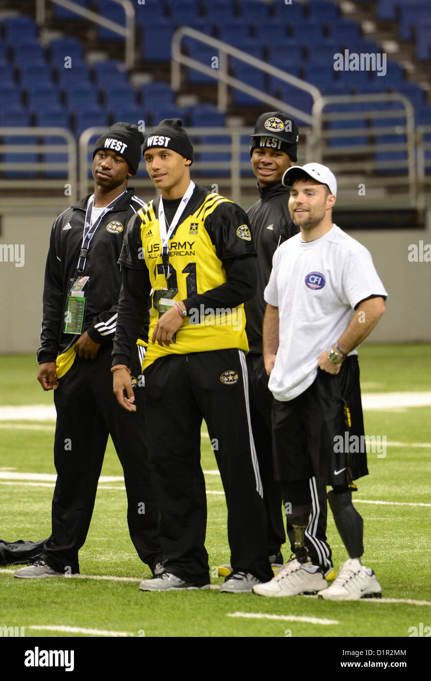 U.S. Army Reserve Spc. Justin Lane (right) teams up with high school football players at the Alamodome in San Antonio Jan. 2, 2013. The student athletes are participating in the U.S. Army All-American Bowl, scheduled to be held Jan. 5, and represent the best high school athletes from across the nation. Lane, a Green Bay, Wis., native, and other wounded warriors teamed up with the student athletes for football challenges, including punting, kicking and throwing. The Army has hosted the All-American Bowl in San Antonio since 2002, engaging with more than 1,300 schools nationwide. (U.S. Army Rese Stock Photo