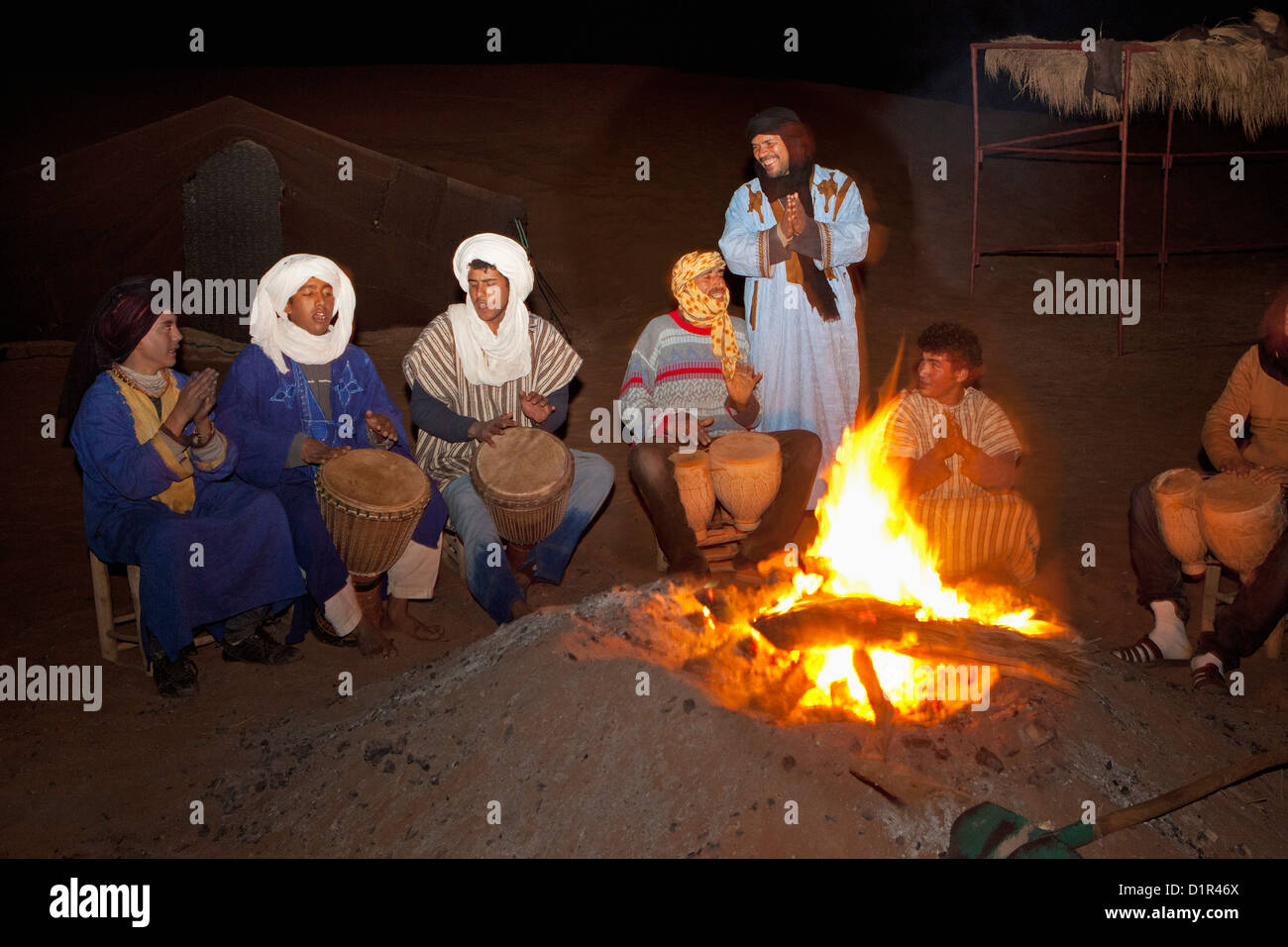 Morocco, M'Hamid, Erg Chigaga. Sahara desert. Tourist camp, bivouac. Local Berber people making music around fireplace. Stock Photo