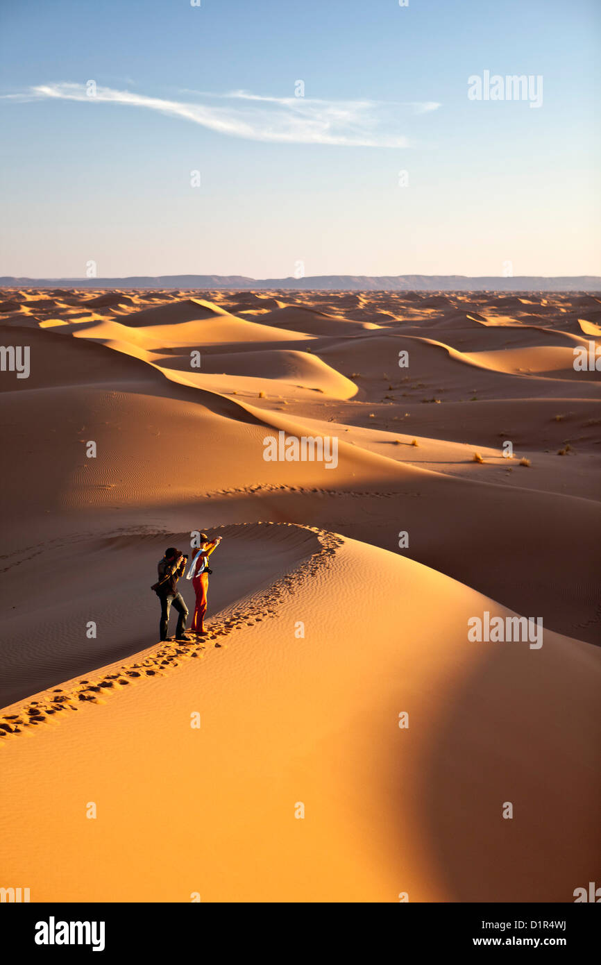 Morocco, M'Hamid, Erg Chigaga sand dunes. Sahara desert. Tourists on sand dune. Stock Photo