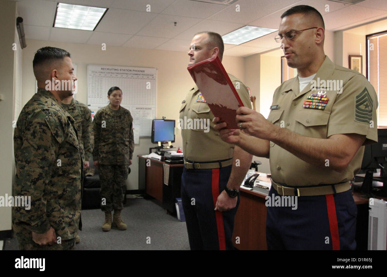 Sgt. Maj. Wallace M. Mains, sergeant major of Marine Corps Recruiting Station Phoenix, reads a promotion warrant for then Staff Sgt. Roque Palmerinvega, left, promoted to the next rank of gunnery sergeant, during a ceremony at the R.S. Phoenix Headquarters in Phoenix, Jan. 2, 2013. Palmerinvega, a native of Myton, Utah, and a light armored vehicle crewman by trade, has been a recruiter in the Phoenix region since April, 2010. 'It's a big deal and a requires a much broader sense of leadership,' Maj. Steven M. Ford, commanding officer of R.S. Phoenix, said of Palmerinvega's promotion. 'It's a qu Stock Photo