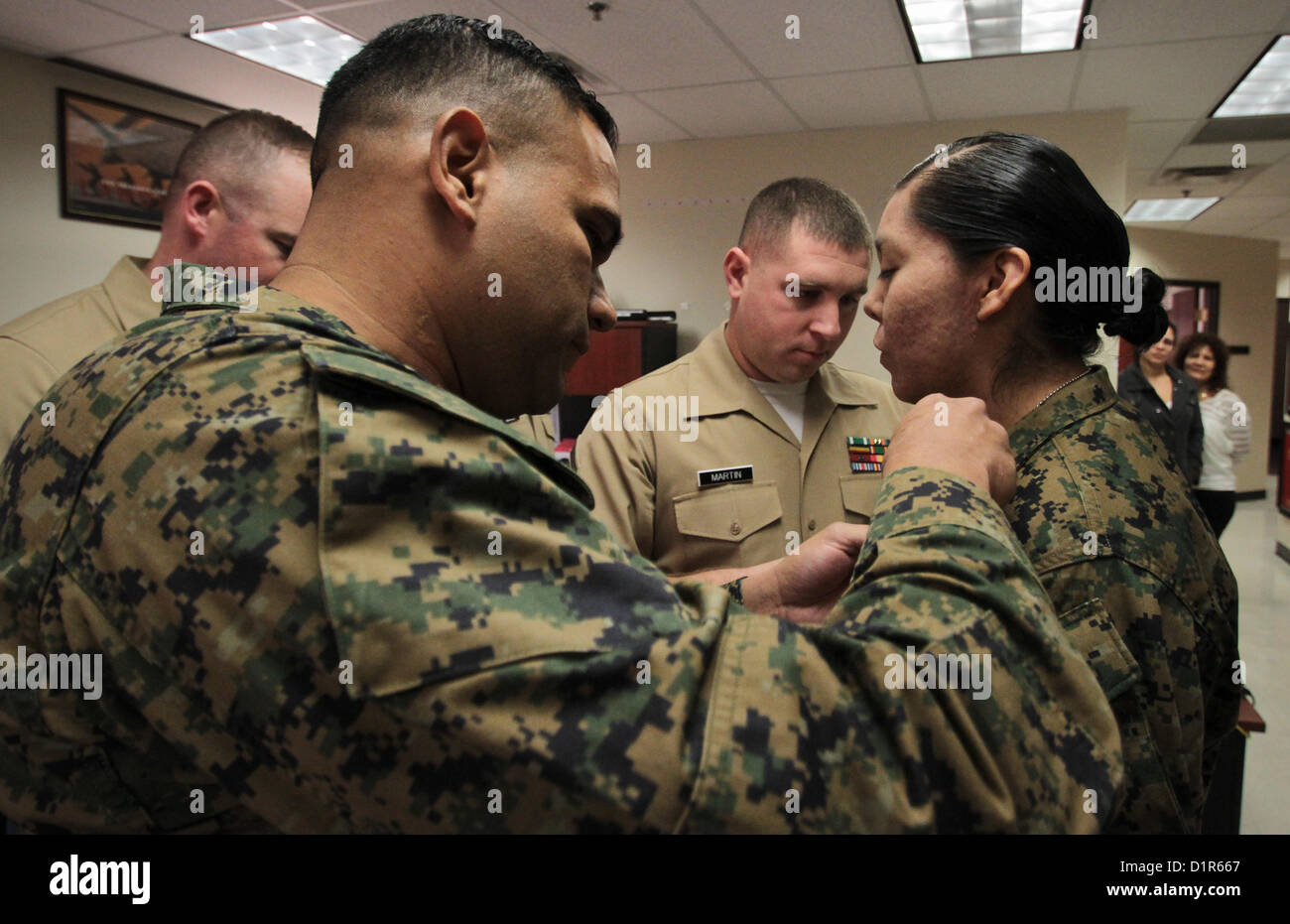 Lance Cpl. Reba K. James, receives new lance corporal chevrons on her collar upon being promoted from private first class to lance corporal during a ceremony at the Marine Corps Recruiting Station Phoenix Headquarters in Phoenix, Jan. 2, 2013. James, a native of Pinon, Ariz., enlisted into the Marine Corps in May of 2012 and is in the Phoenix region temporarily assisting recruiters before she returns to her Marine occupational specialty training at the Defense Information School at Fort George G. Meade, Md. James is training to become a combat correspondent. 'I remember her being in the delaye Stock Photo