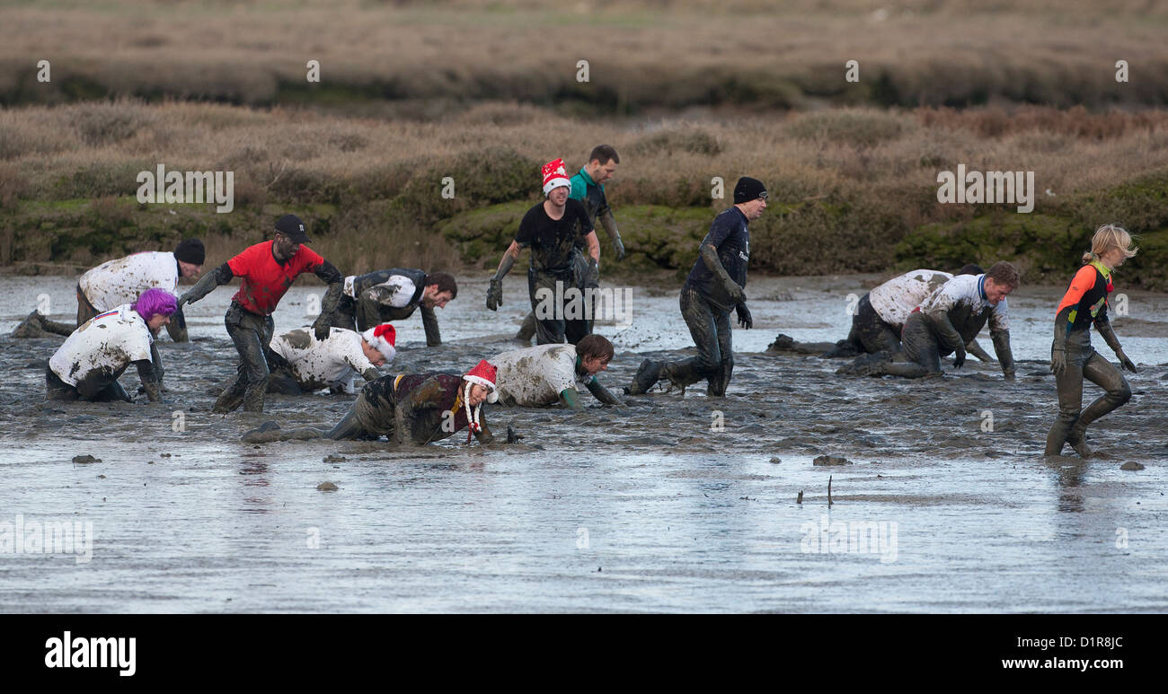 Competitors struggle through the thick mud during the annual Maldon Mud Race in Maldon in Essex. Stock Photo
