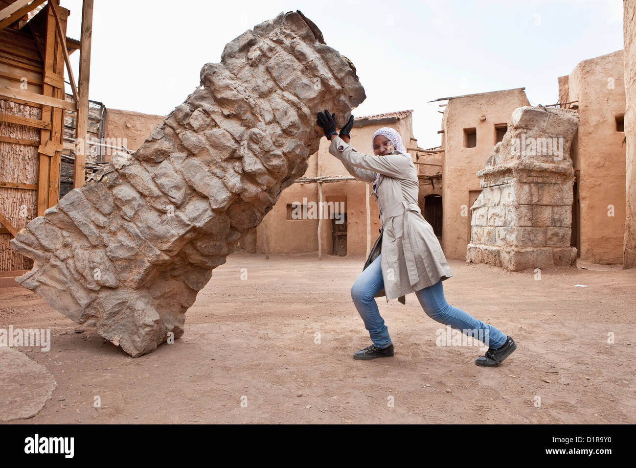Morocco, near Ouarzazate, Local guide at Atlas Film Studios shows that bricks are not heavy. Stock Photo