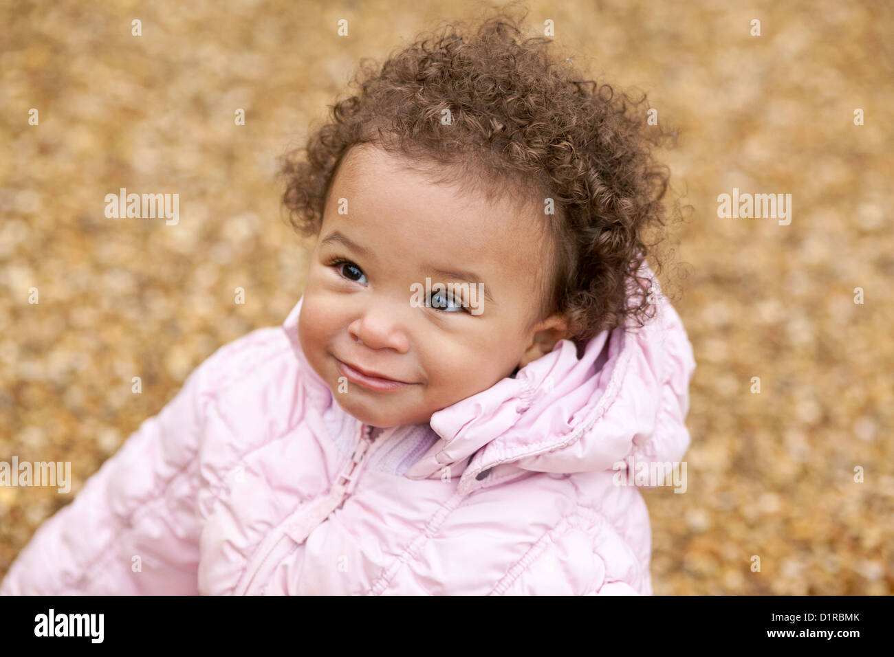 Outdoors portrait of cute happy toddler mixed race girl wearing a pink  coat,warm protective boots and leggings Stock Photo - Alamy