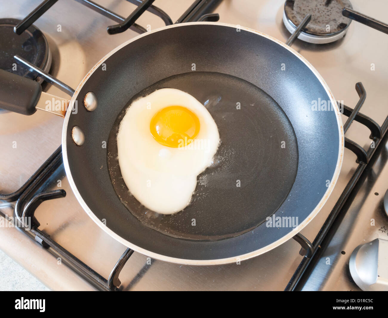 An egg being fried in sunflower oil in a small Teflon coated non stick