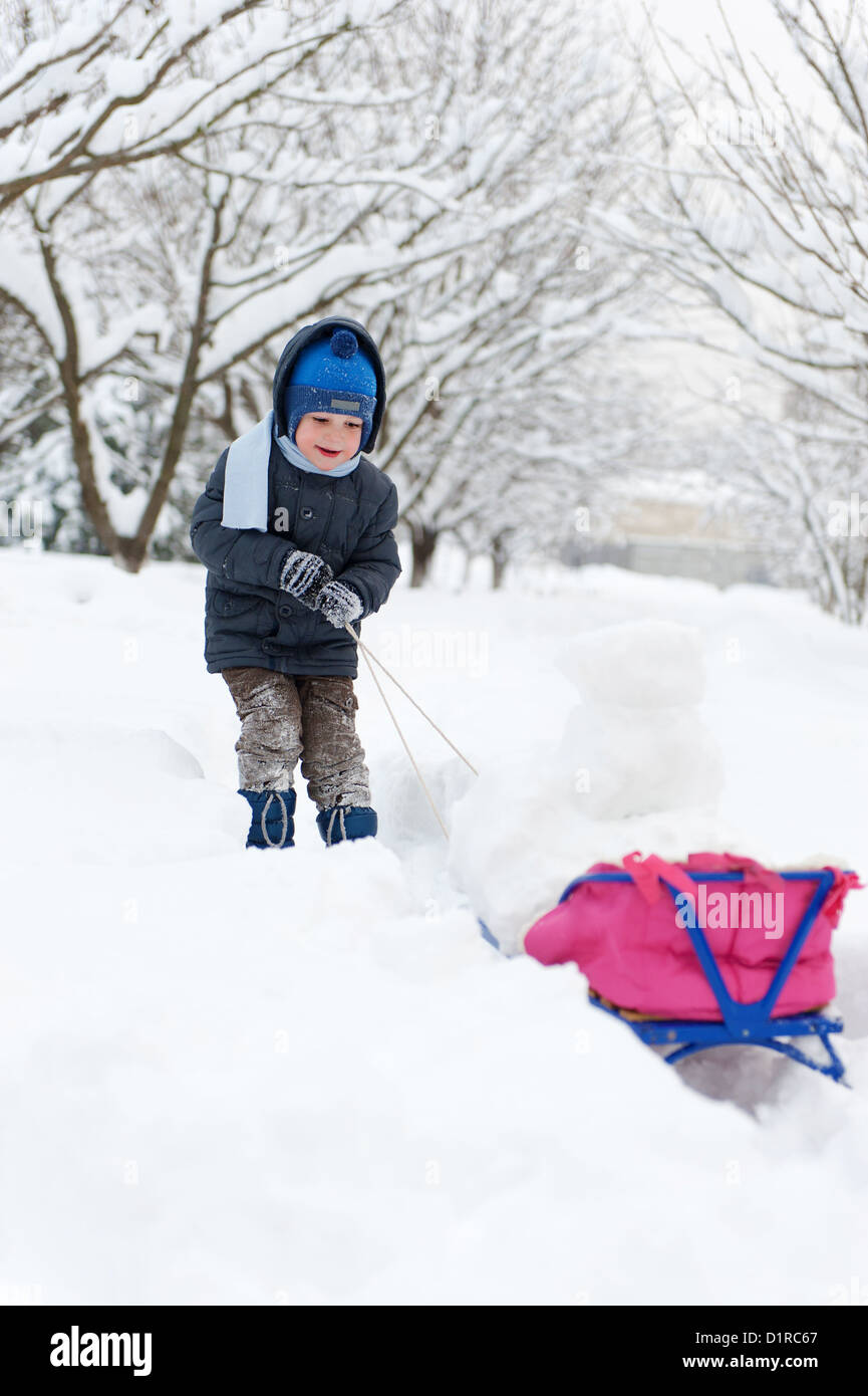 Cute little boy sledding in snow forest Stock Photo Alamy