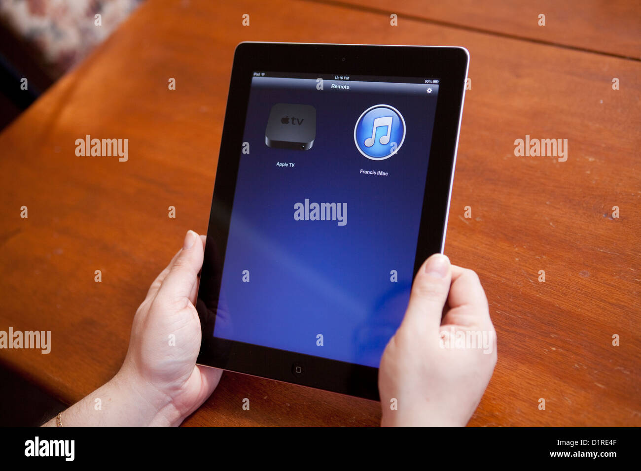 A woman uses the Remote app on an iPad 4 to controle an Apple TV Stock  Photo - Alamy