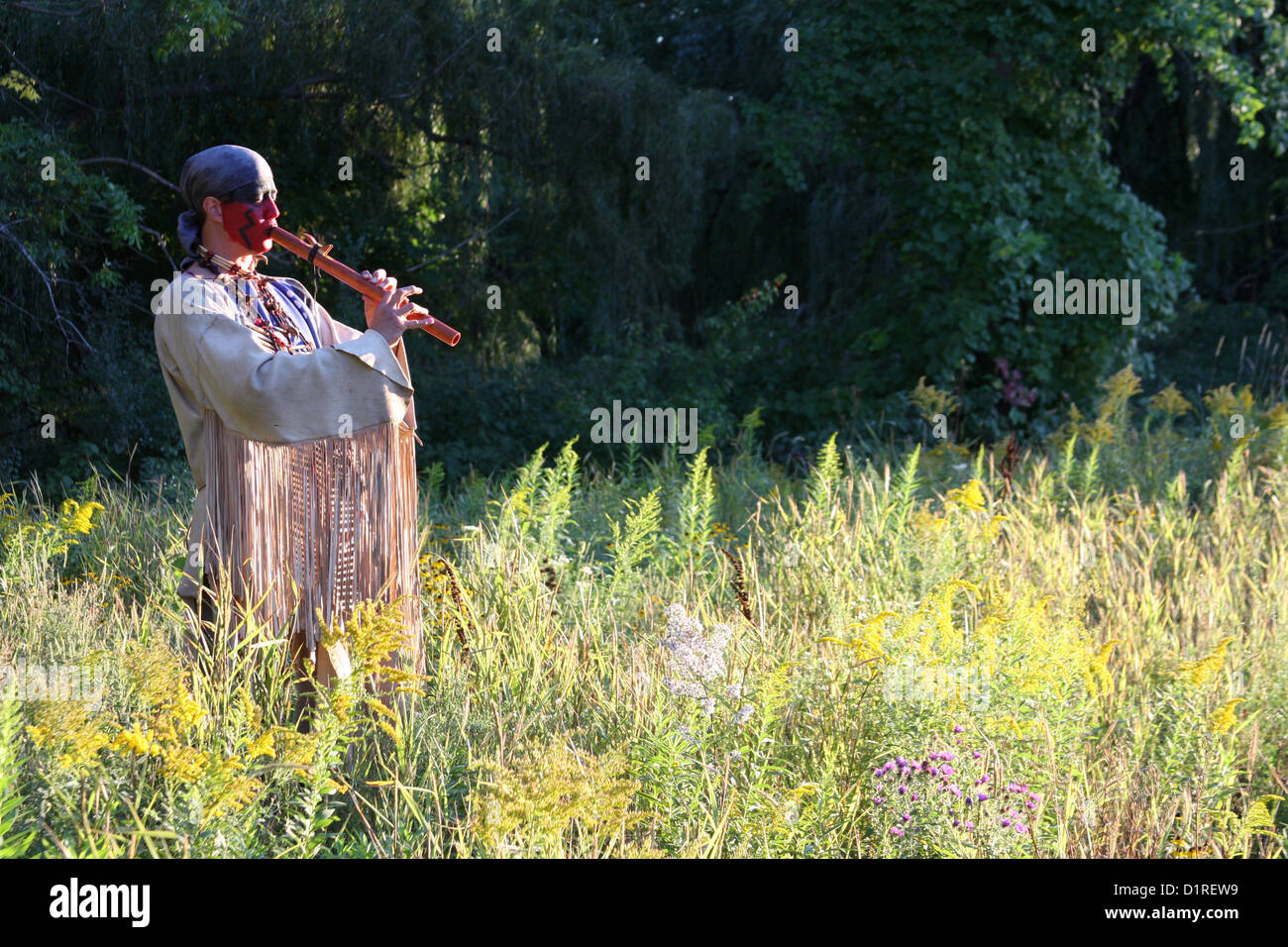 A Native American Indian man playing a wooden flute outside in nature Stock  Photo - Alamy