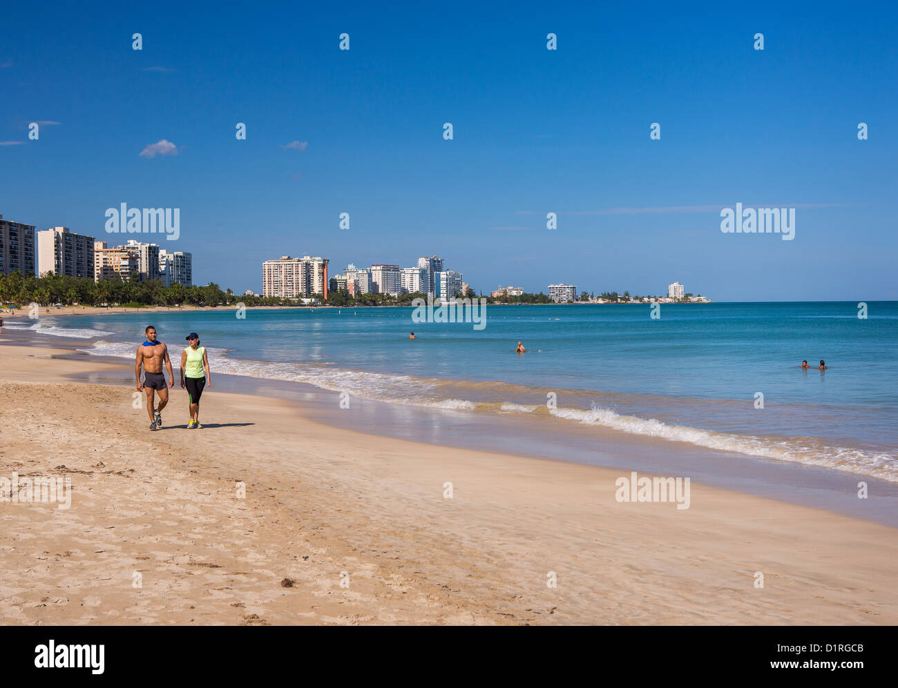 SAN JUAN, PUERTO RICO - Couple walks on beach at Isla Verde beach resort. Stock Photo