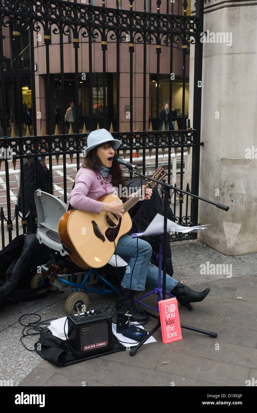 A political, socially aware protest folk singer outside Liverpool Street station London in 2007 before the 'crash' Stock Photo
