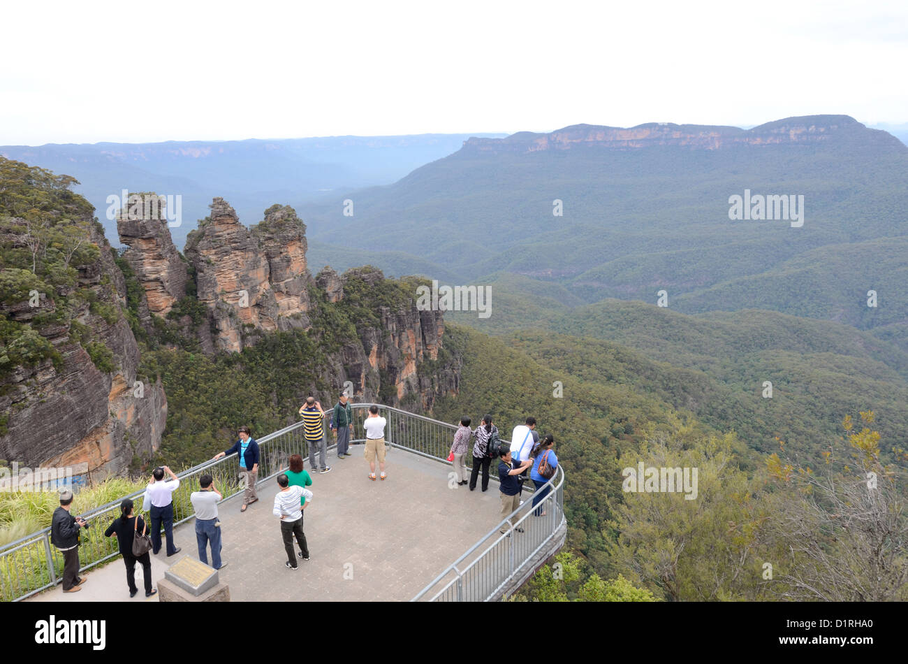 KATOOMBA, Australia - Tourists stand on one of the viewing platfooms at Echo Point in the Blue Mountains overlooking the rock formation known as the Three Sisters. Katoomba, New South Wales, Australia. Stock Photo