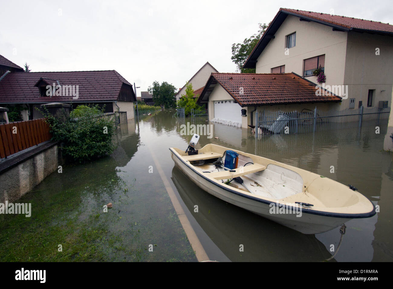 Flooded house after heavy rain with motor boat on the street. Stock Photo