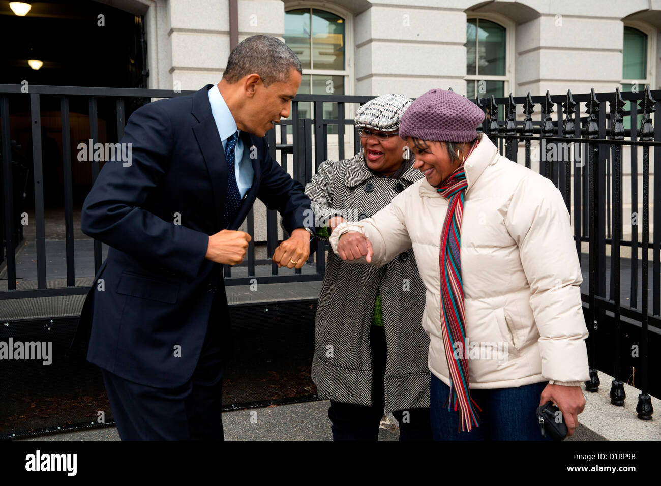 US President Barack Obama greets a couple of government workers with an elbow bump following remarks on the fiscal cliff negotiations as he walked back to the White House December 31, 2012 in Washington, DC. Stock Photo