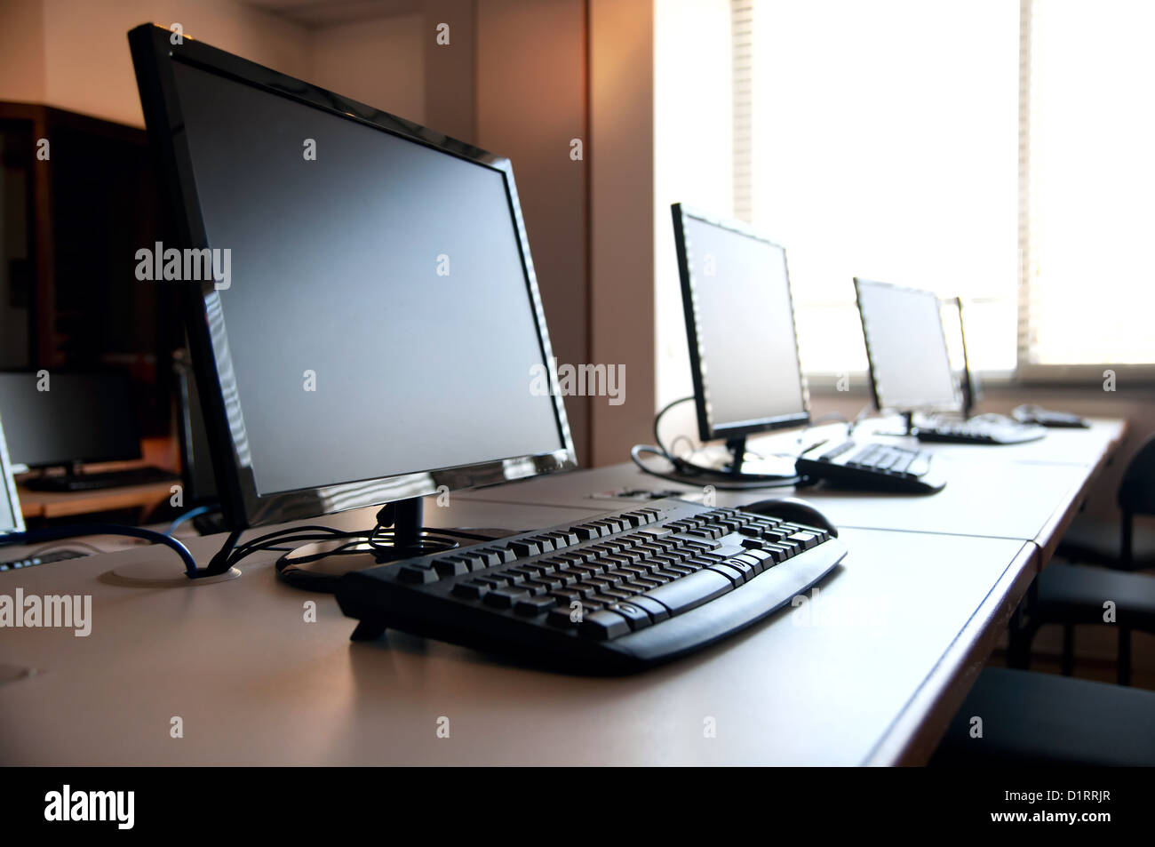 Row of desktop PCs workplaces in the classroom Stock Photo