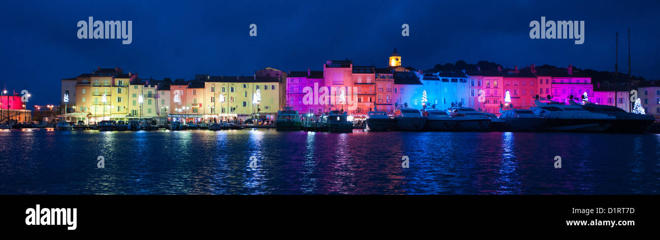 A panoramic display of the colorful Christmas light decorations in St Tropez, France. The rainbow array is also reflected below. Stock Photo