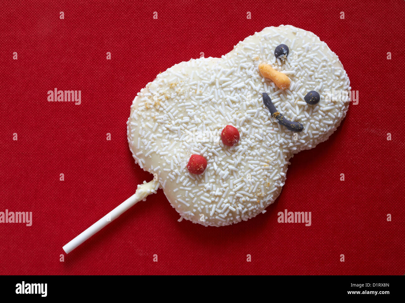 Snowman biscuit lolly on stick isolated on red background Stock Photo