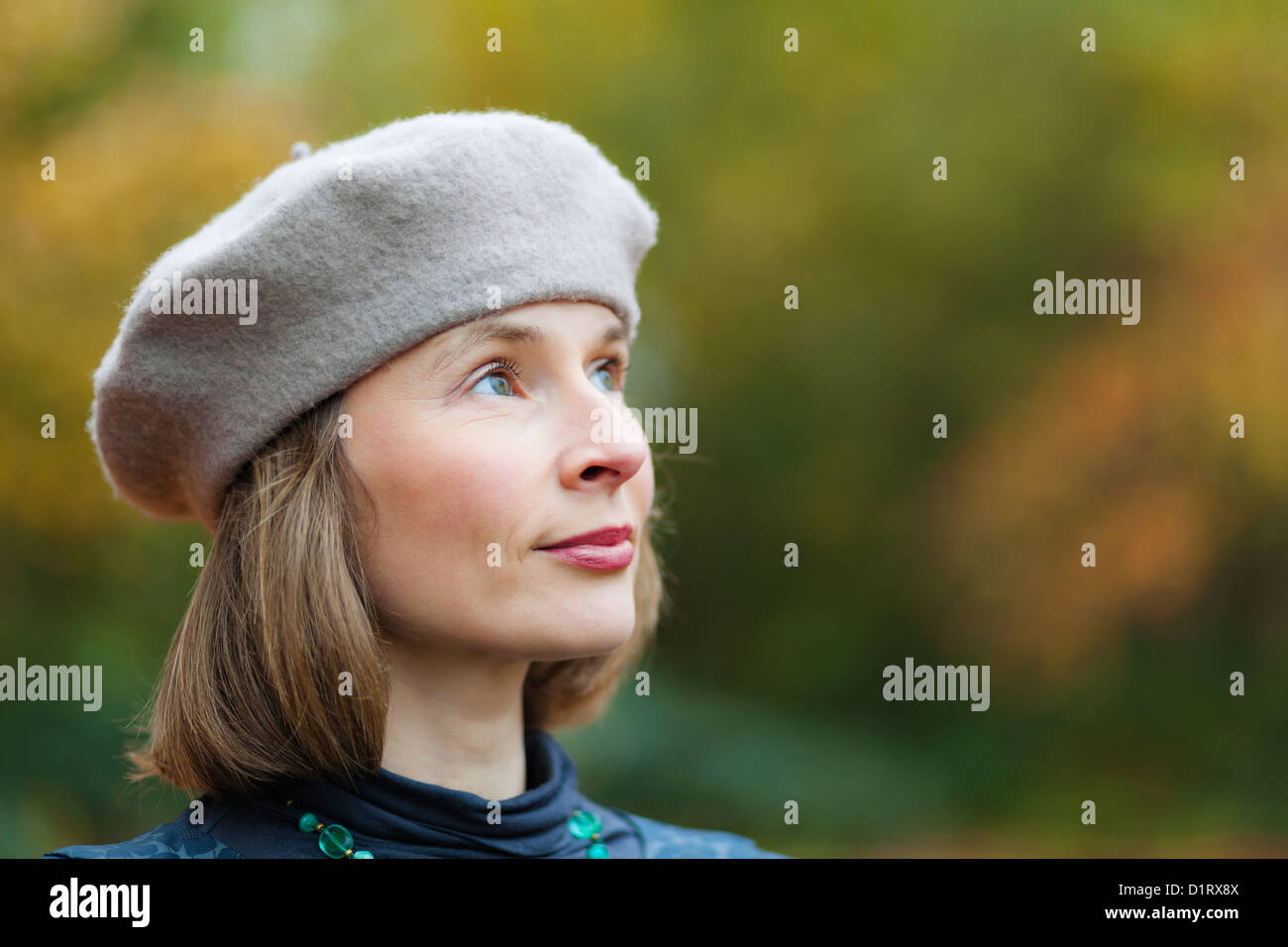 Outdoor portrait of cheerful middle aged woman wearing grey beret Stock Photo