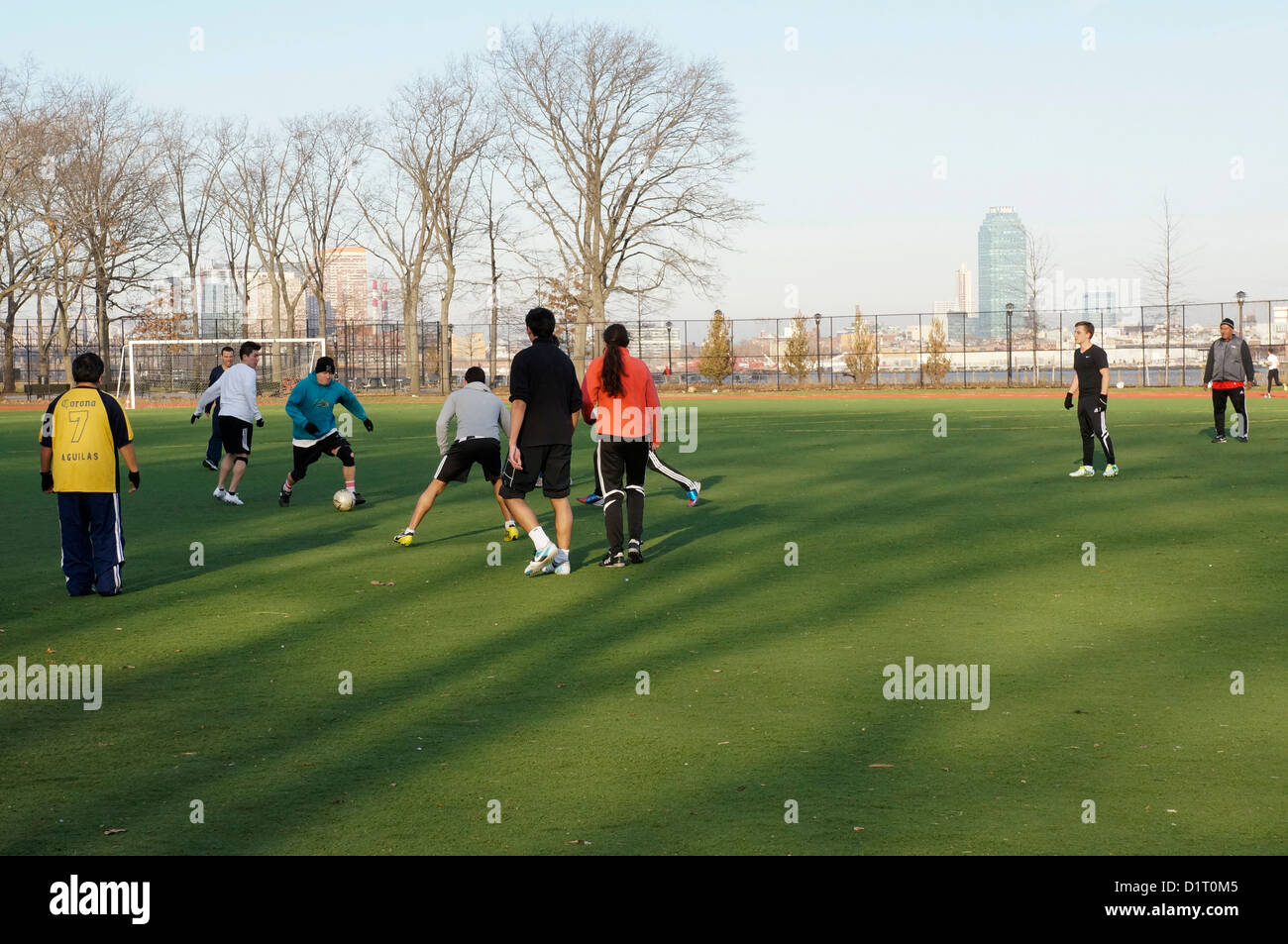 Men and boys playing soccer along the riverfront on the East River in