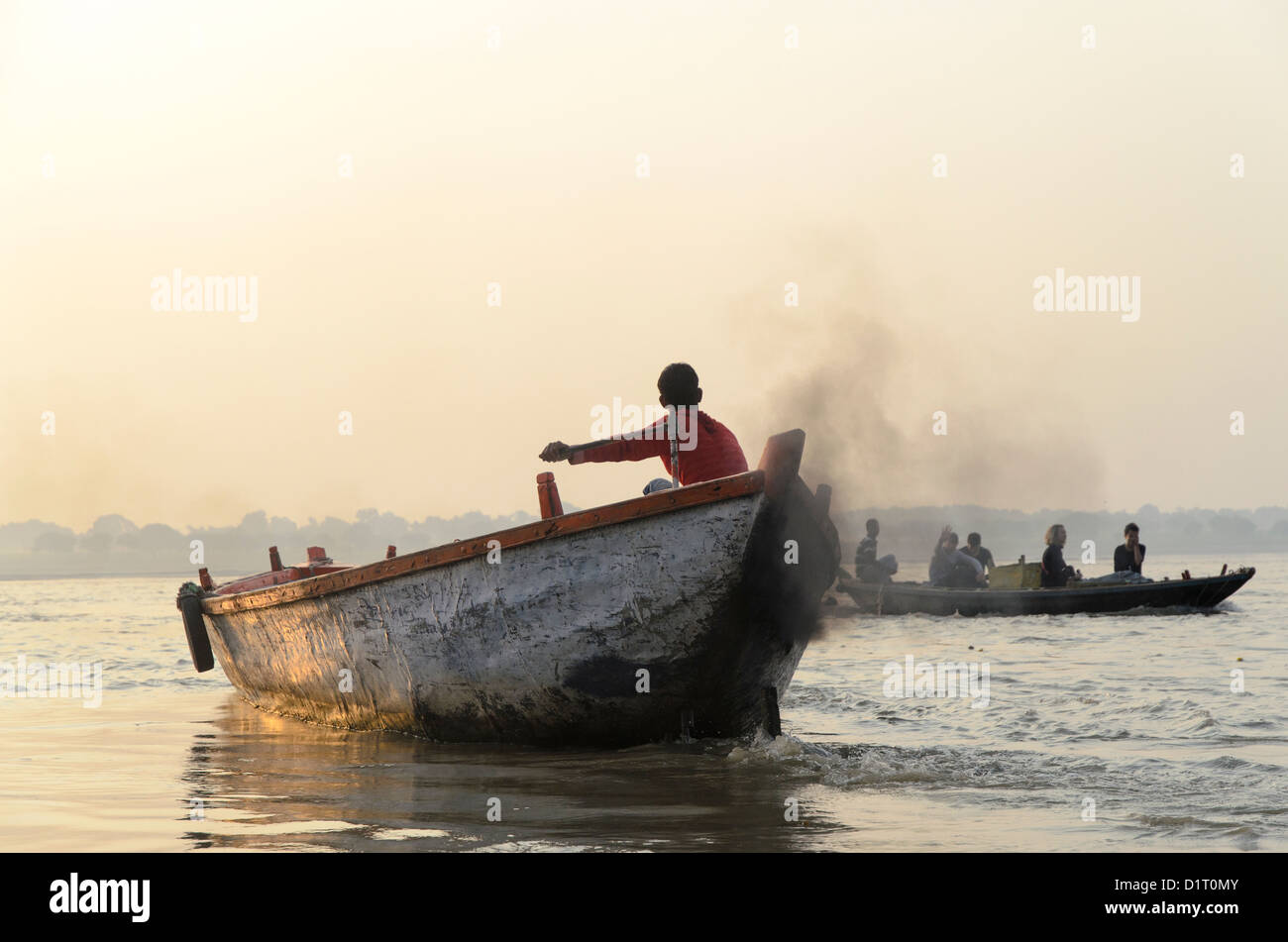 Waving coxswain and boat trip at the morning on Ganges in Varanasi, India Stock Photo