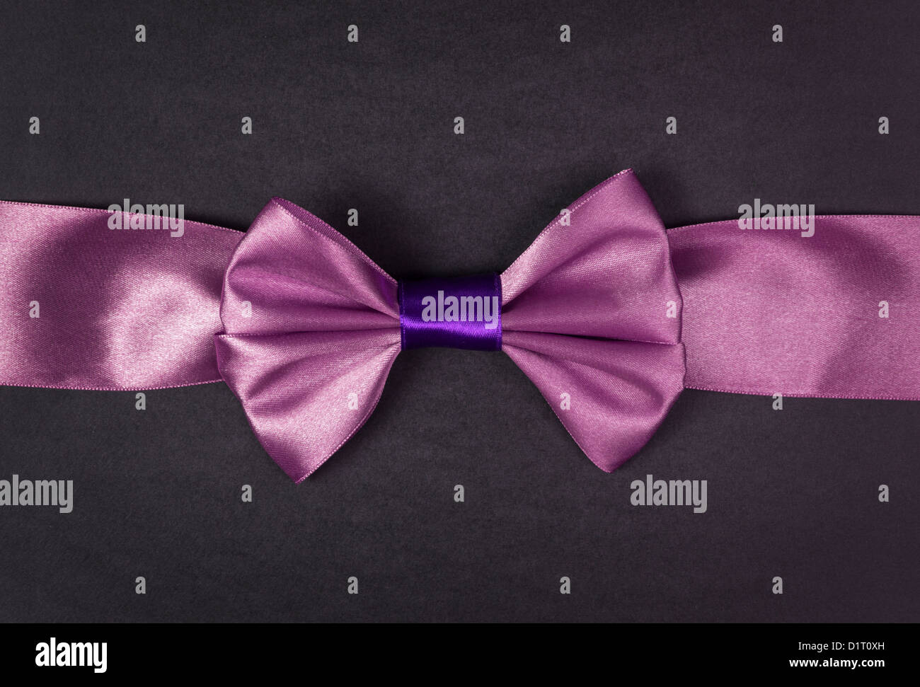 purple ribbon bow on black paper background Stock Photo - Alamy