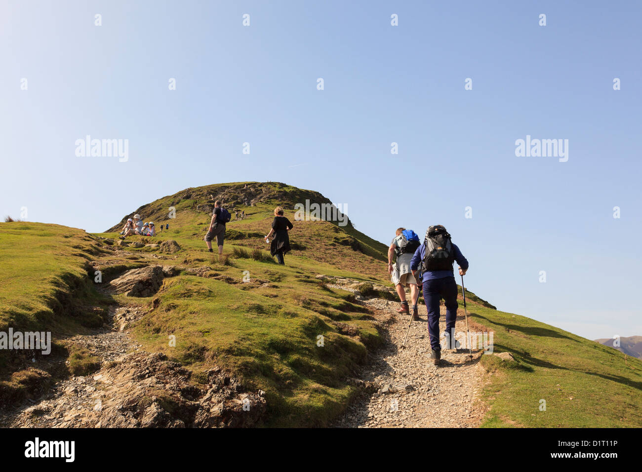 People walking on worn eroded path up Catbells mountain ridge in Lake ...