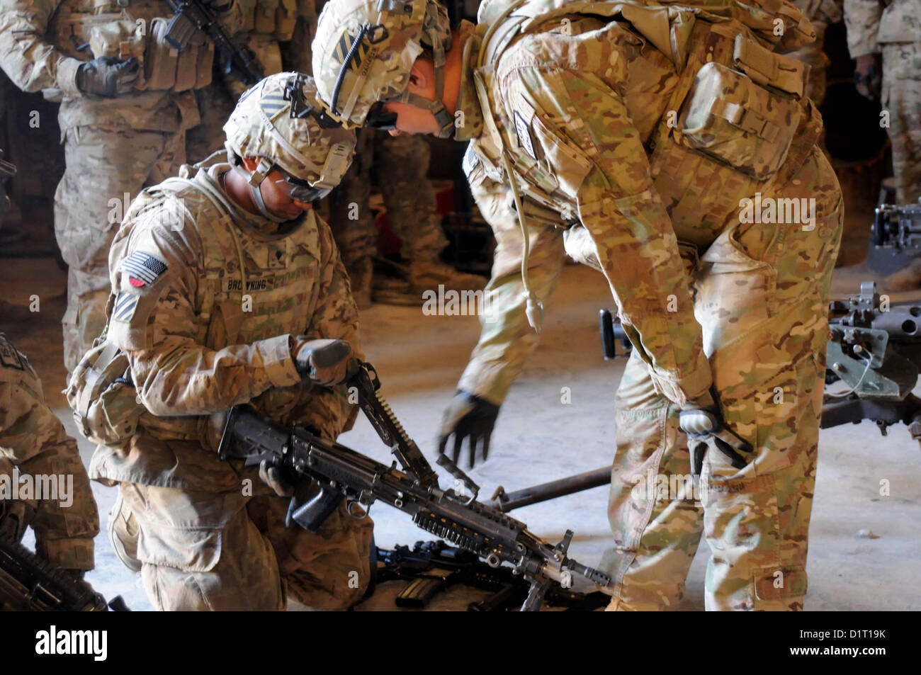 FORWARD OPERATING BASE SMART, Afghanistan -- U.S. Army Sgt. Eric Huerta, a gunner with the Zabul Provincial Reconstruction Team, assists U.S. Army Spc. Terrell Browning, Z PRT security force, with clearing the M249 Squad Automatic Weapon during a safety stand down day at Forward Operating Base Smart, Afghanistan, Jan. 3. 2013  Throughout the day members of Z PRT participated in briefings and exercises focused on safety-related topics to include winter injuries, suicide prevention and vehicle safety. (U.S. Air Force by Senior Airman Patrice Clarke) Stock Photo