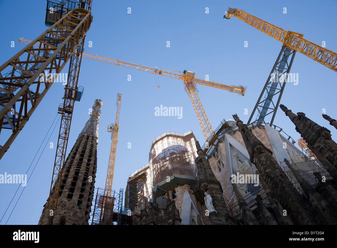 Cranes and construction workers outside the Sagrada Familia in Barcelona, Spain Stock Photo