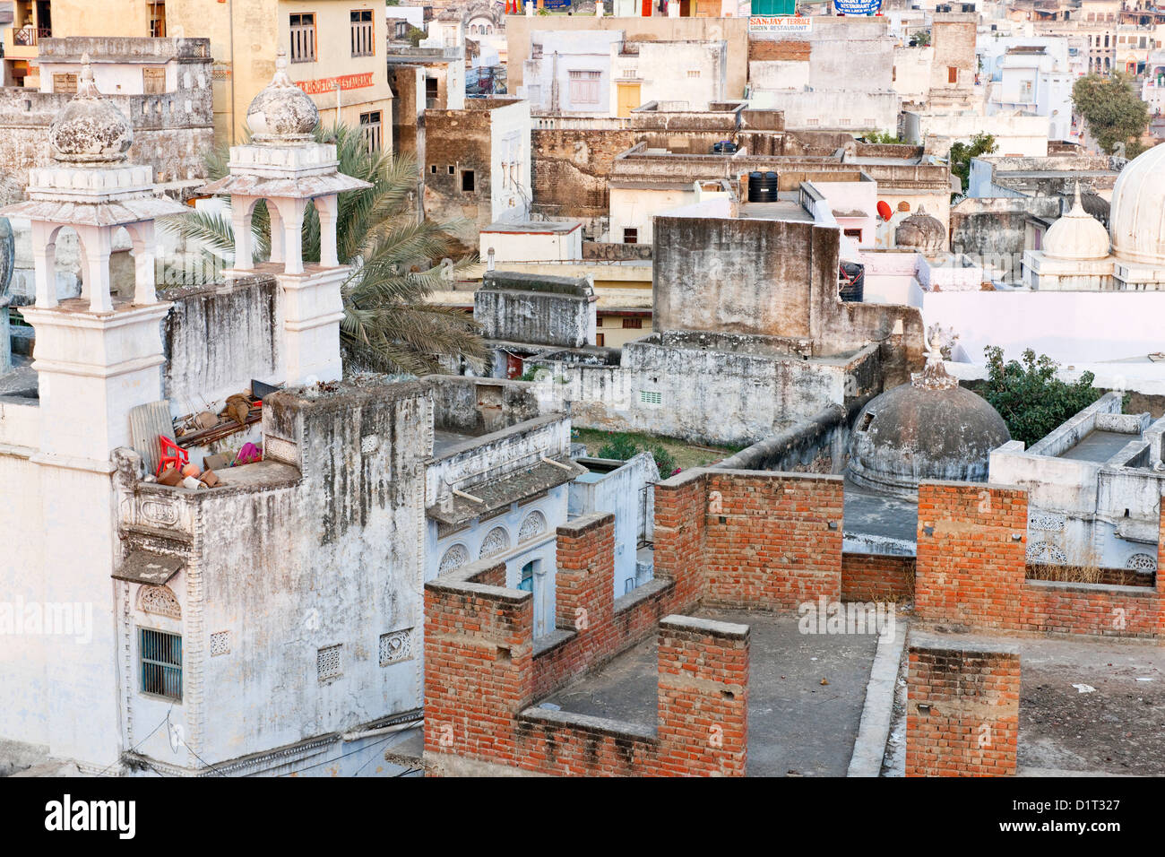 A view of the colorful rooftops of Pushkar  Rajasthan India with a red chair and geometric shapes of buildings Stock Photo