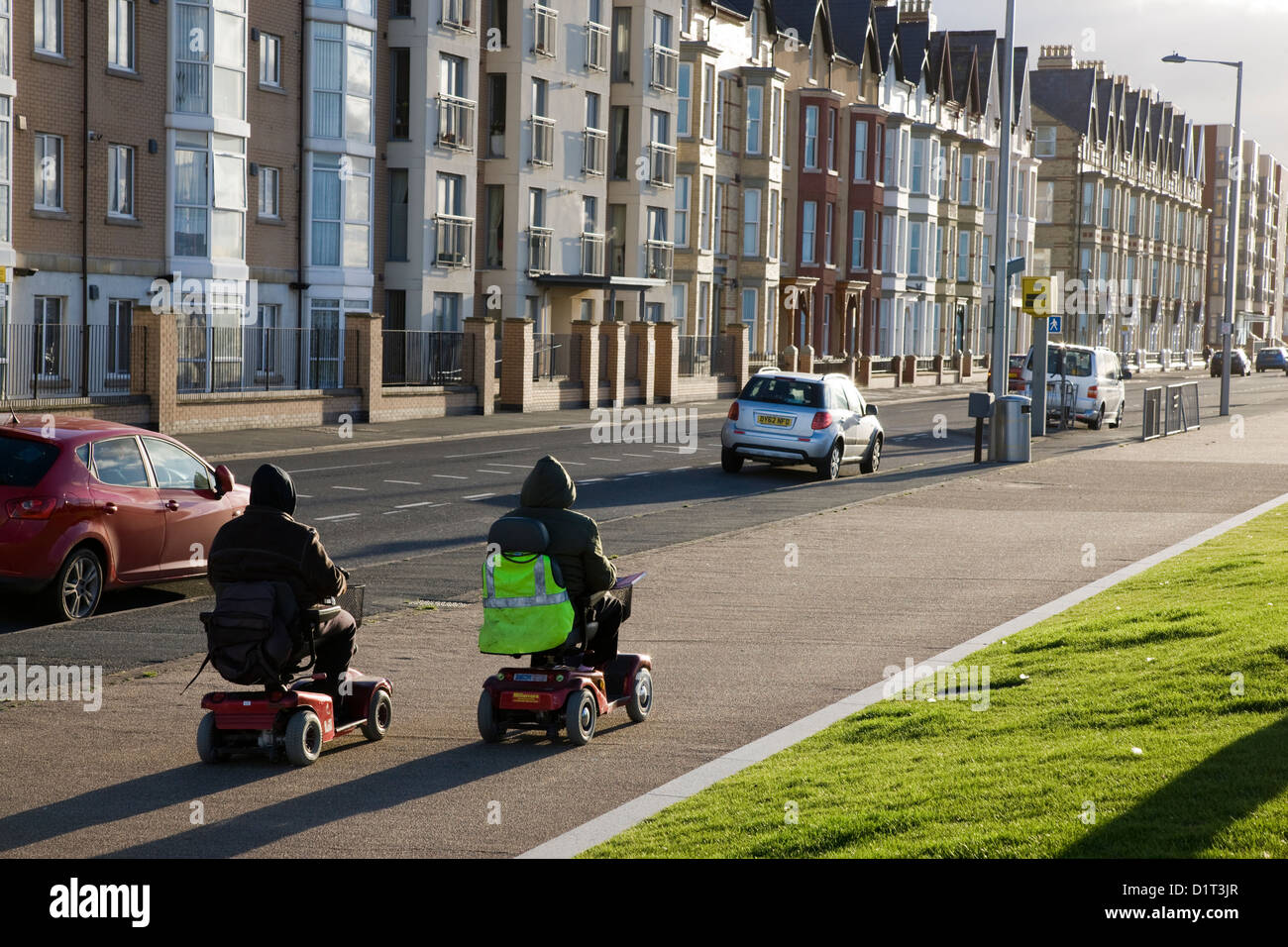 Two mobility scooters approaching a speed camera in Rhyl, Wales Stock Photo