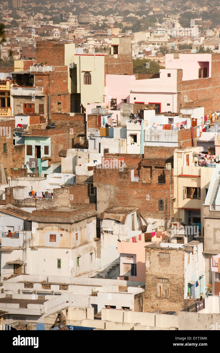 A view of the colorful rooftops of Udaipur Rajasthan India with some people and washing lines and geometric shapes of buildings Stock Photo