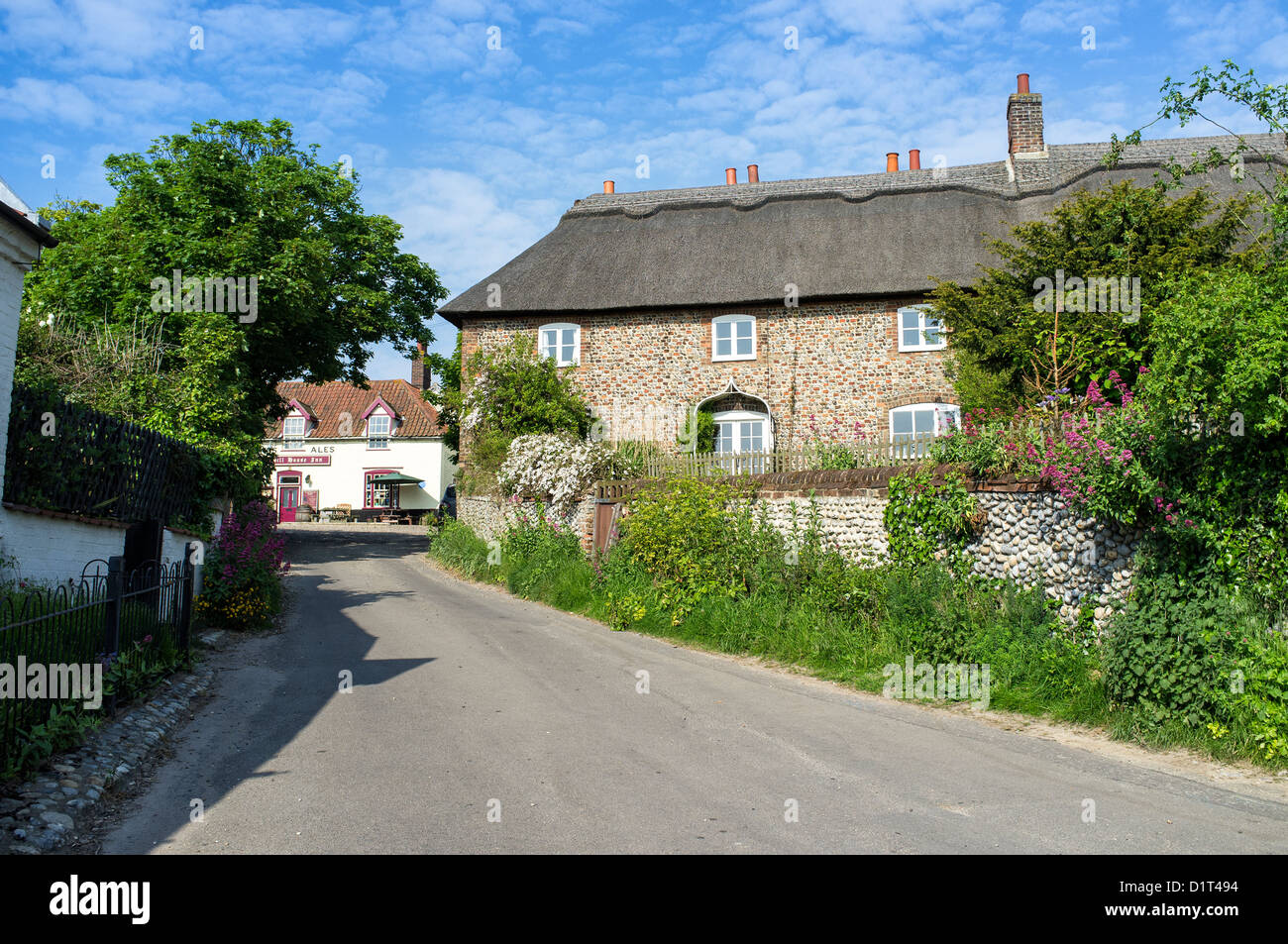 Lane Leading past Thatched Cottages to The Hill House Inn at Happisburgh Norfolk UK Stock Photo
