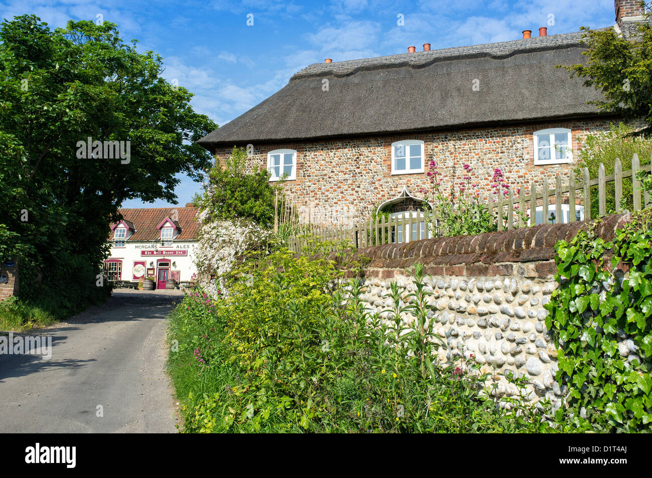 Lane Leading past Thatched Cottages to The Hill House Inn at Happisburgh Norfolk UK Stock Photo