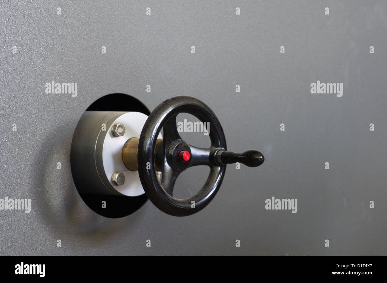 heavy duty industrial crank on a textured gray metal machine Stock Photo