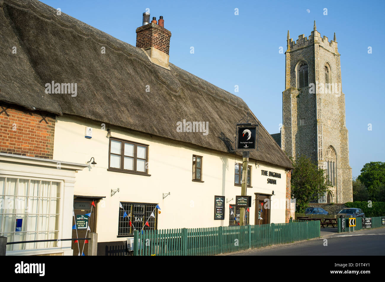 The Swan Pub and Restaurant at Ingham Norfolk UK with the Church of Holy Trinity Stock Photo