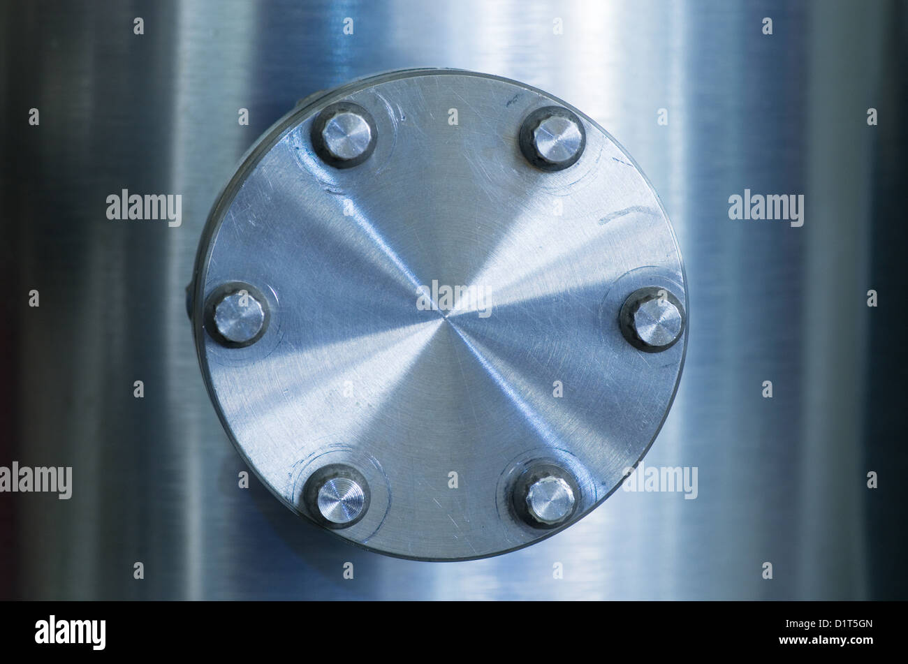bolted on flange cover on an industrial brushed metal vacuum pipe Stock Photo