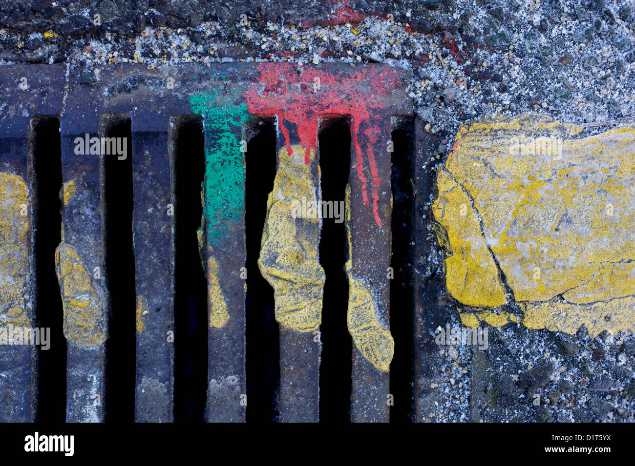 Roadside drain cover with red green and yellow paint Stock Photo