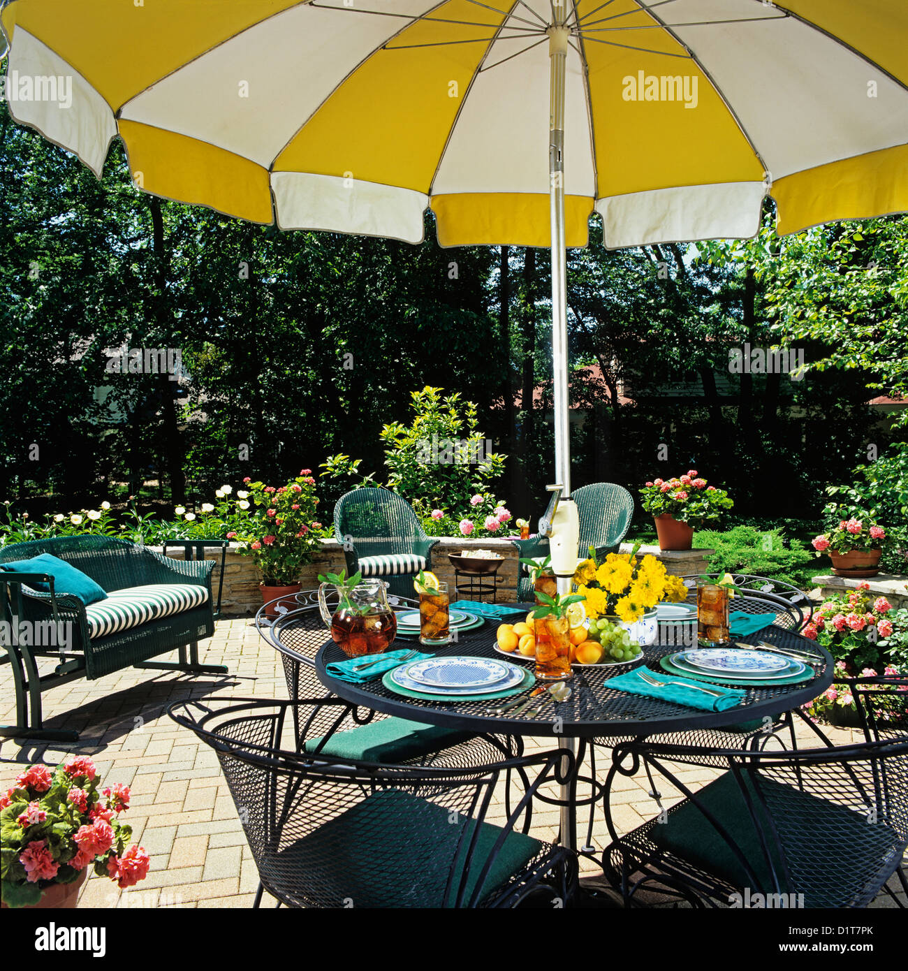 PATIOS Close up umbrella table and surrounding wicker furniture small