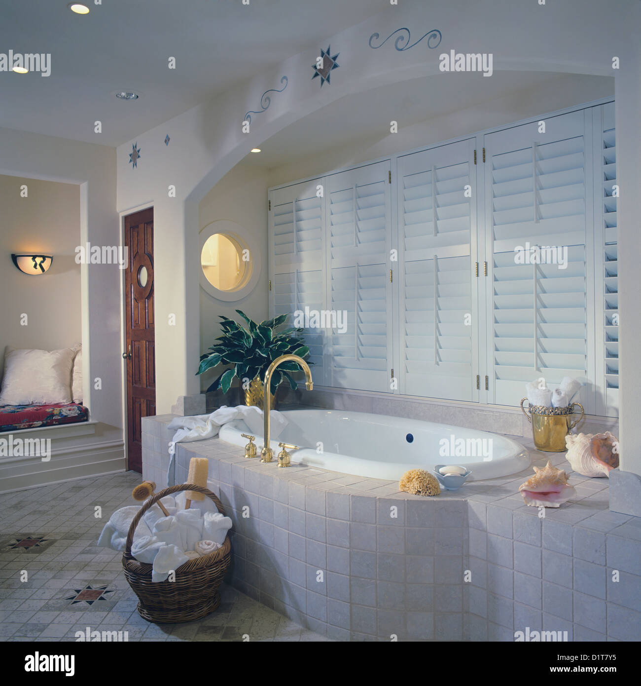 BATHROOM Tub with tile surround set in arched alcove with shuttered
