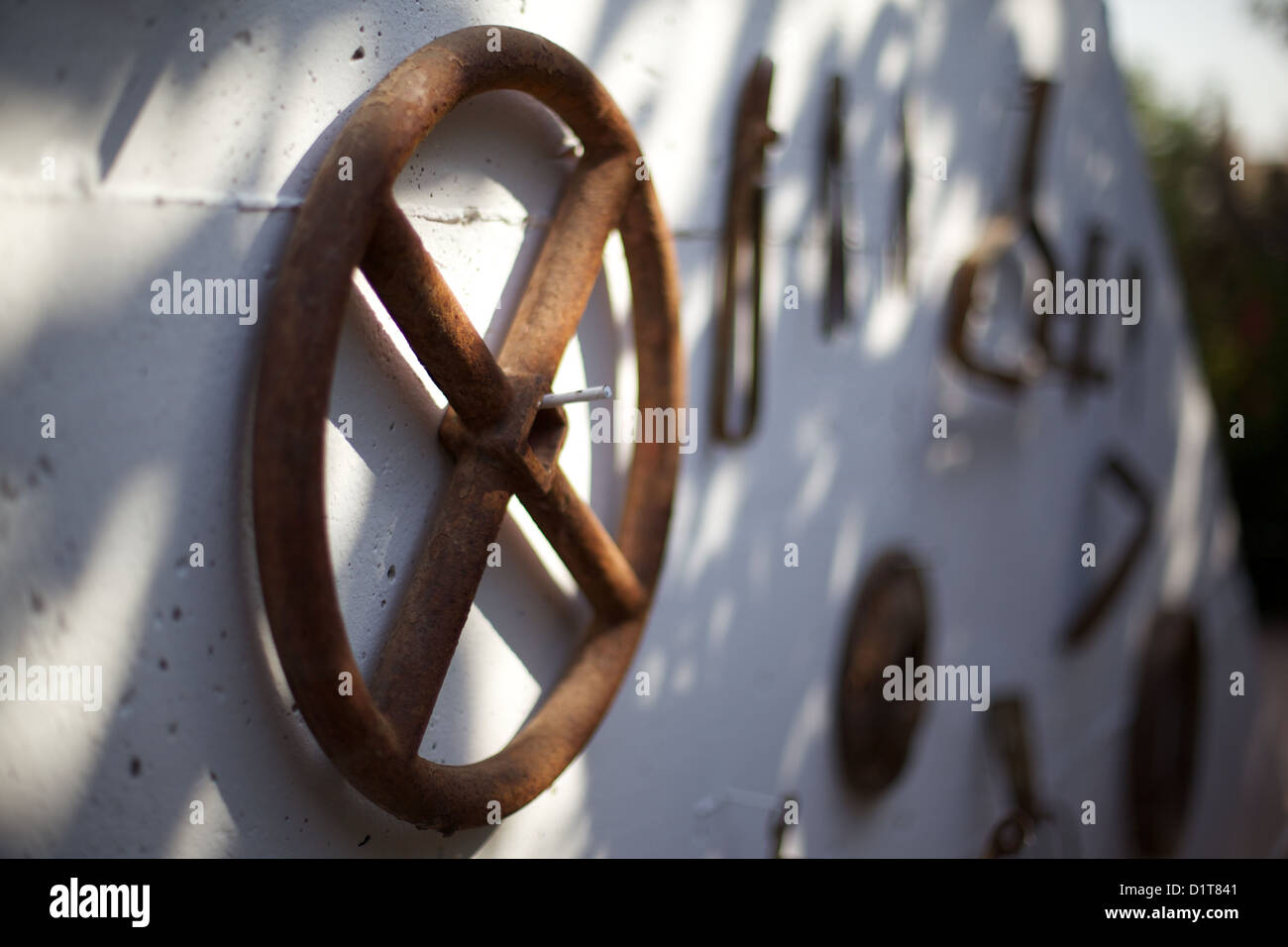 Old, rusting, farm tools hanging on a wall Stock Photo