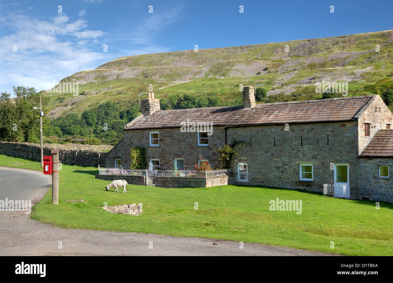 Stone cottage with post box and sheep, Reeth, Yorkshire Dales, England Stock Photo