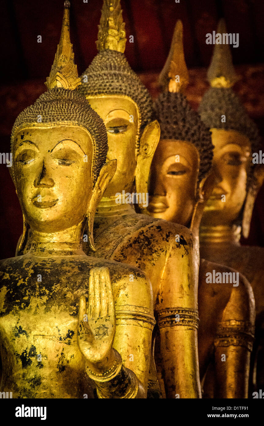 LUANG PRABANG, Laos - A line of gold Buddha statues at Wat Mai Suwannaphumaham.  Wat Mai, as it is often known, is a Buddhist temple in Luang Prabang, Laos, located near the Royal Palace Museum. It was built in the 18th century and is one of the most richly decorated Wats in Luang Prabang. Stock Photo